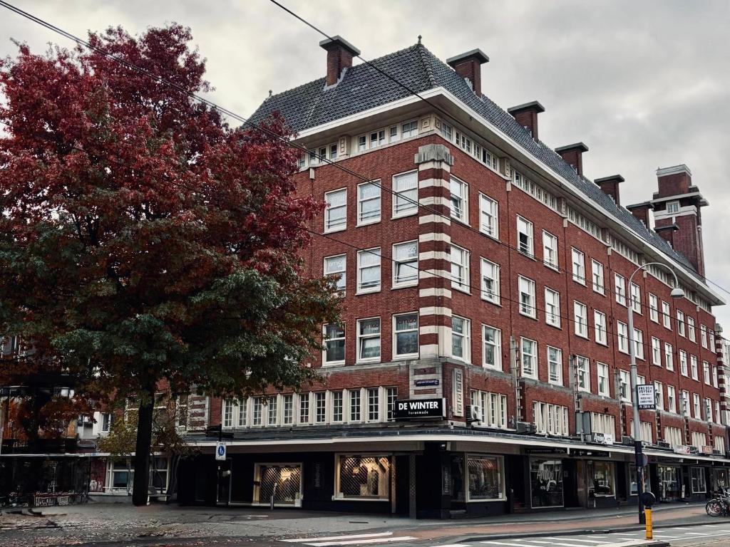 a large red brick building on a city street at Amigo Hostel in Amsterdam