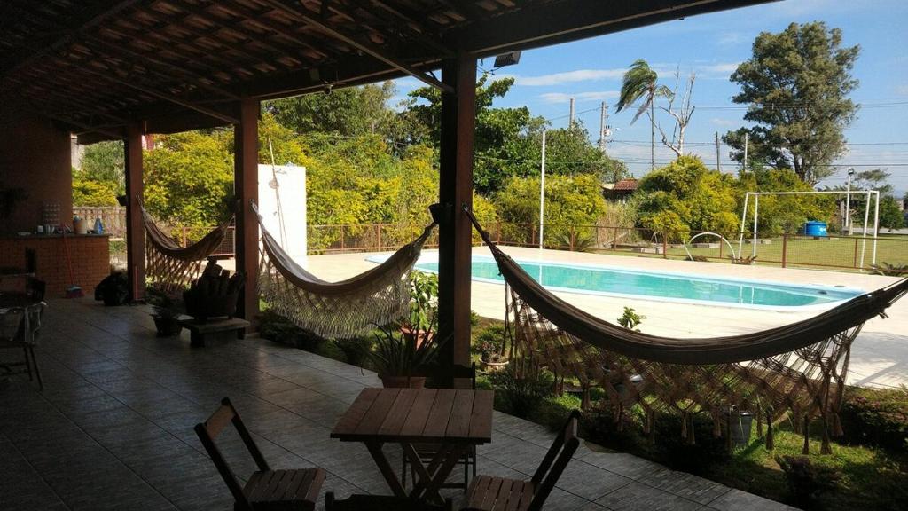 un patio con hamacas y una piscina en Espaço Recanto do Guerreiro, en Pindamonhangaba