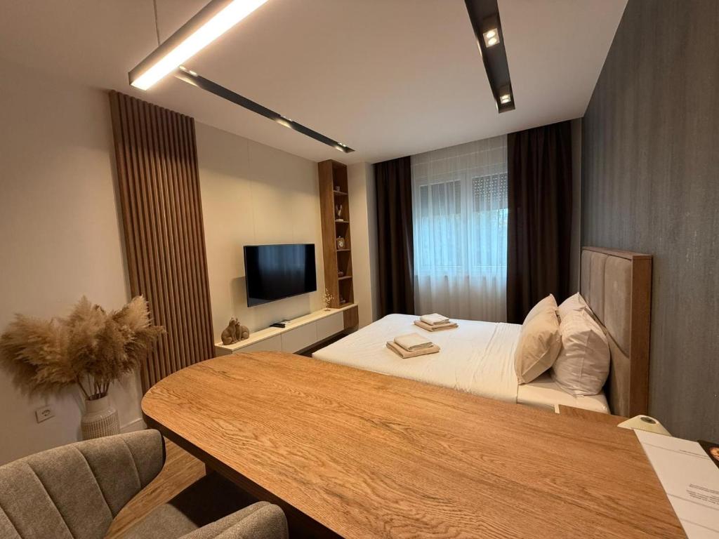 a hotel room with a bed and a table at IL PRIMO Studio Apartment in Kragujevac