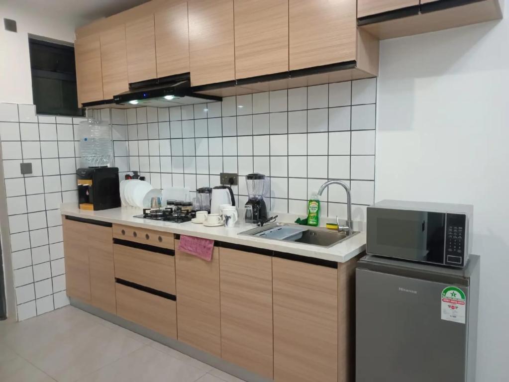 a kitchen with a sink and a microwave at Lester Deluxe Studio Apartment Near Village Market United Nation and Embassies in Ruaka