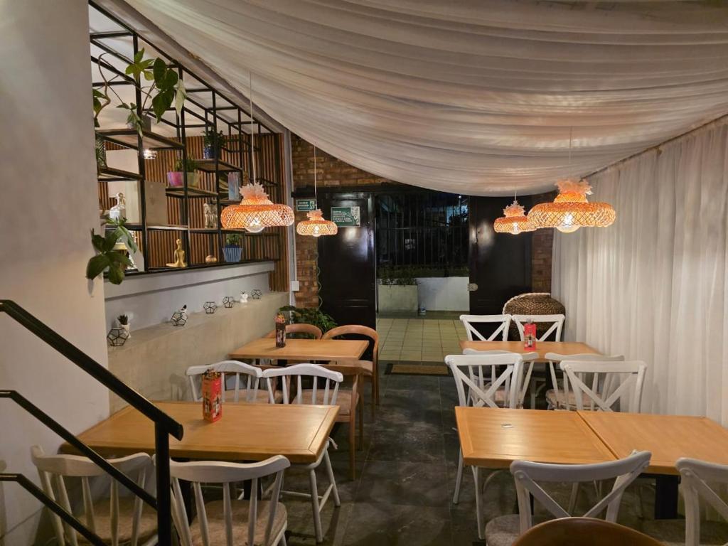 a restaurant with wooden tables and chairs and chandeliers at Freyja Café Bistró - Hostal Boutique in Bogotá
