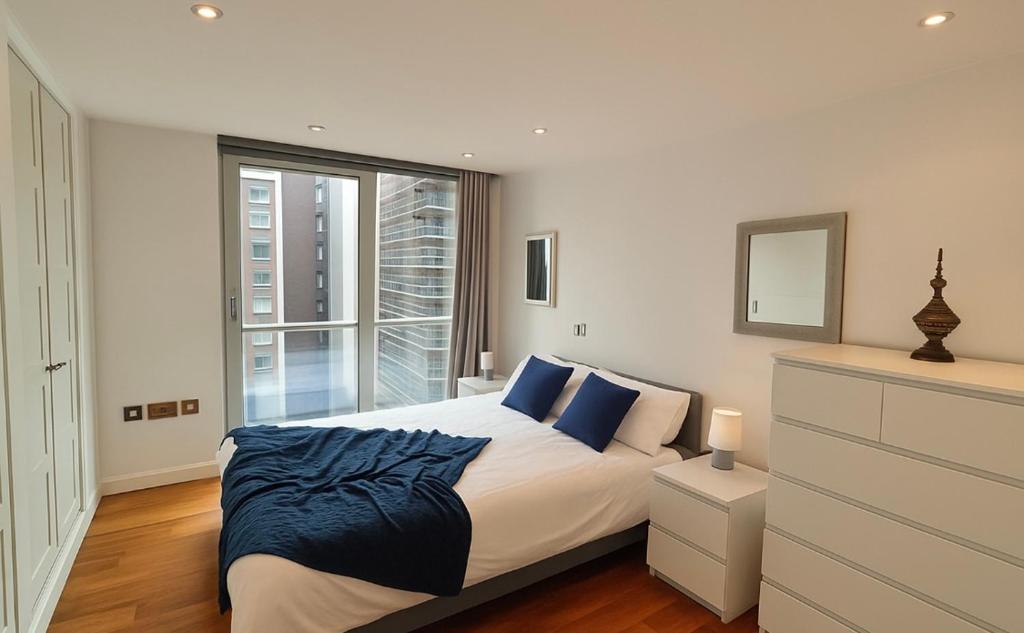 a bedroom with a bed with blue pillows and a window at Lowry River Twin Balcony Deluxe in Manchester