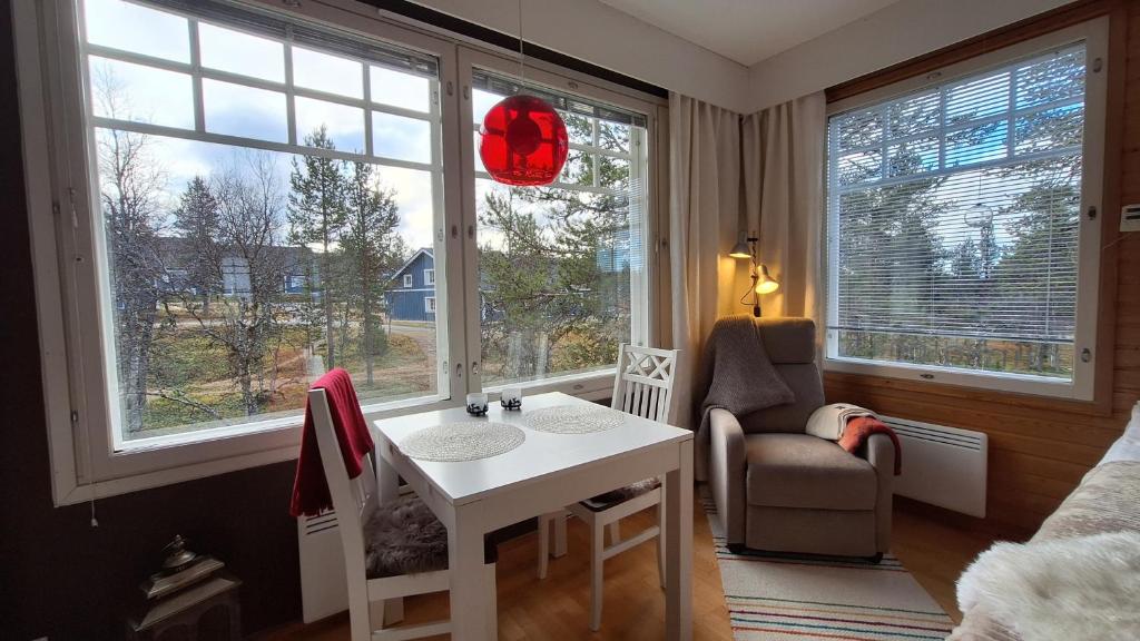 a room with a table and a chair and windows at Studio Robin in Saariselka