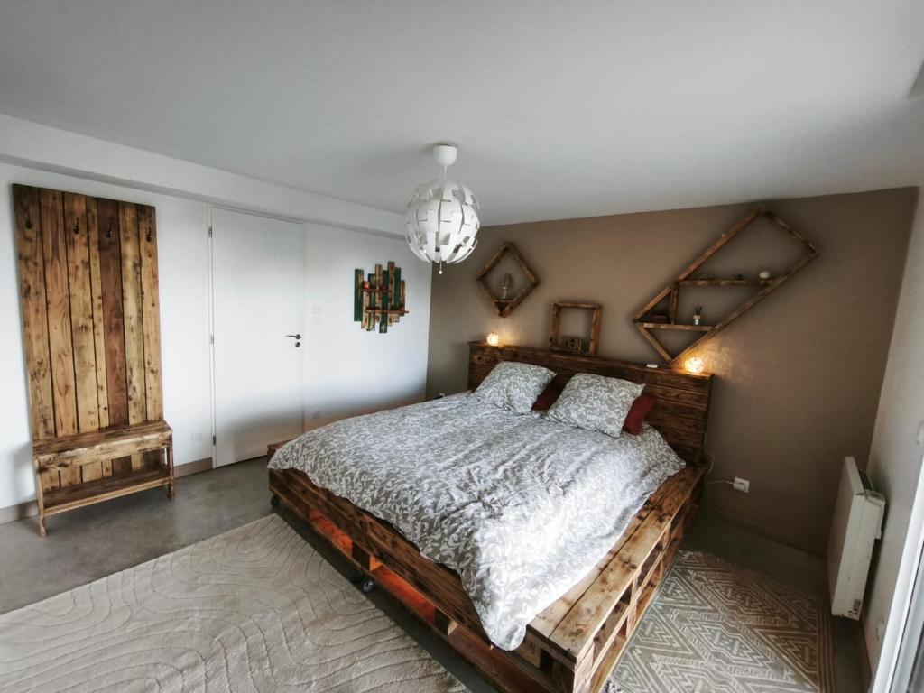 a bedroom with a wooden bed and a chandelier at B&B Spa 60 in Clermont