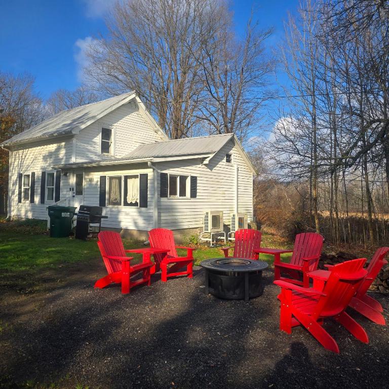 a group of red chairs and a fire pit in front of a house at Big Barn Lodge - Farm House in Pulaski