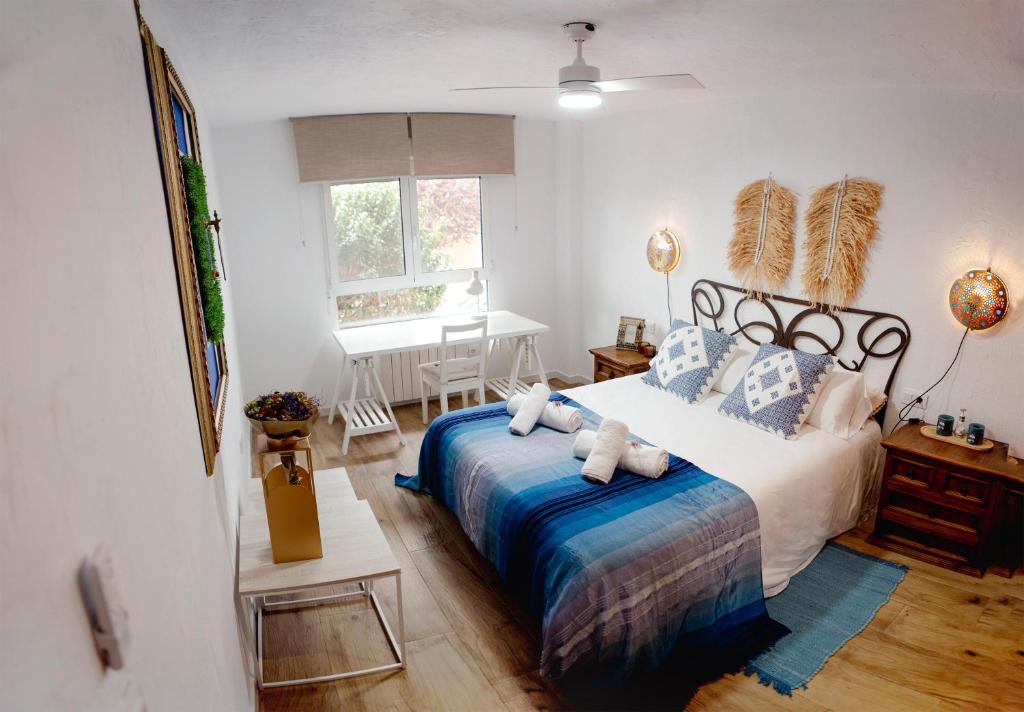 a bedroom with a large bed and a table at Apartamento El Oso y el Madroño II Thematic in Villena