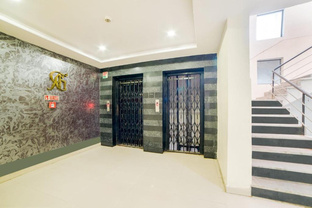 a hallway with a staircase and a door with a mural at Super Capital O Raaga Grand in Hyderabad