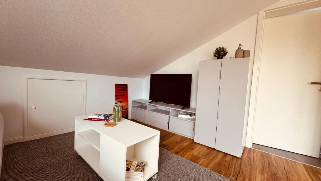 a living room with a tv and a white cabinet at Luxury Apartment in Böblingen in Böblingen