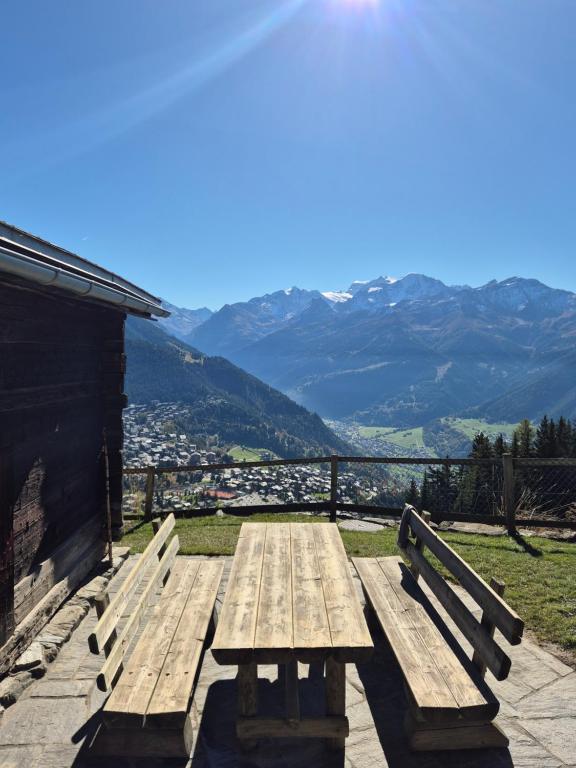 einen Picknicktisch aus Holz mit Bergblick in der Unterkunft Le Raidillon Verbier in Verbier