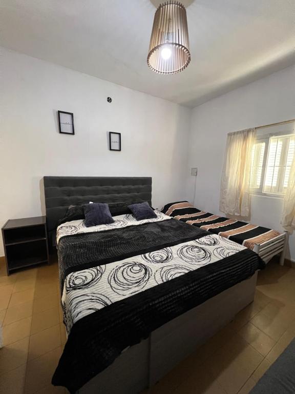a bedroom with two beds and a chandelier at La casita the Aye in Villa Carlos Paz