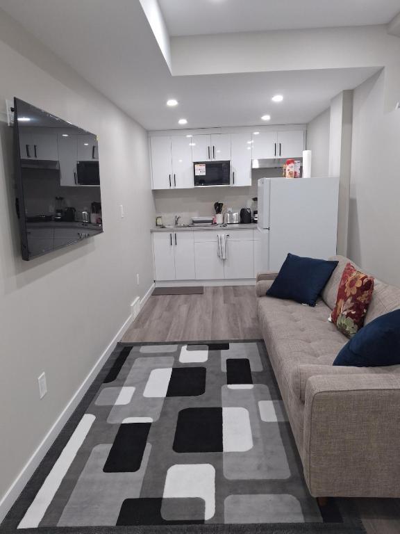a living room with a couch and a kitchen at Oxnard Villa in Winnipeg