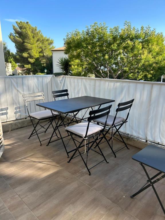 a table and chairs sitting on a patio at 2 pièces, moderne et lumineux avec piscine en résidence privée in Villeneuve-Loubet