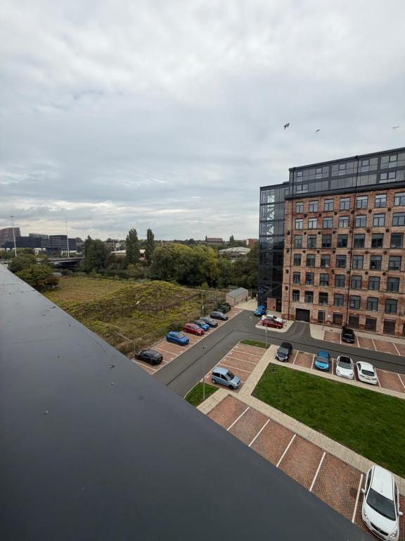 Luftaufnahme eines Parkplatzes mit vor einem Gebäude geparkten Autos in der Unterkunft Luxe Duplex Penthouse Stay in Leeds Centre - Free Parking in Leeds