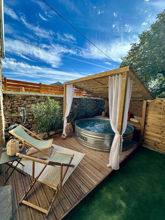 a deck with a hot tub and a gazebo at Gîte de charme en Ardèche in Saint-Étienne-de-Fontbellon