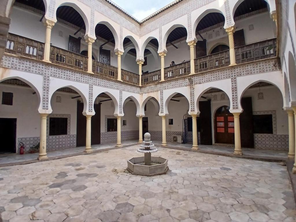 a courtyard of a building with a fountain at Elite location in LʼAgha