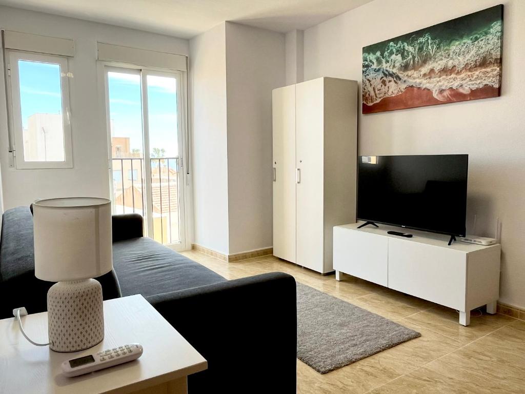 a living room with a couch and a tv at Casa Lilla - Ideal for couples in Los Alcázares
