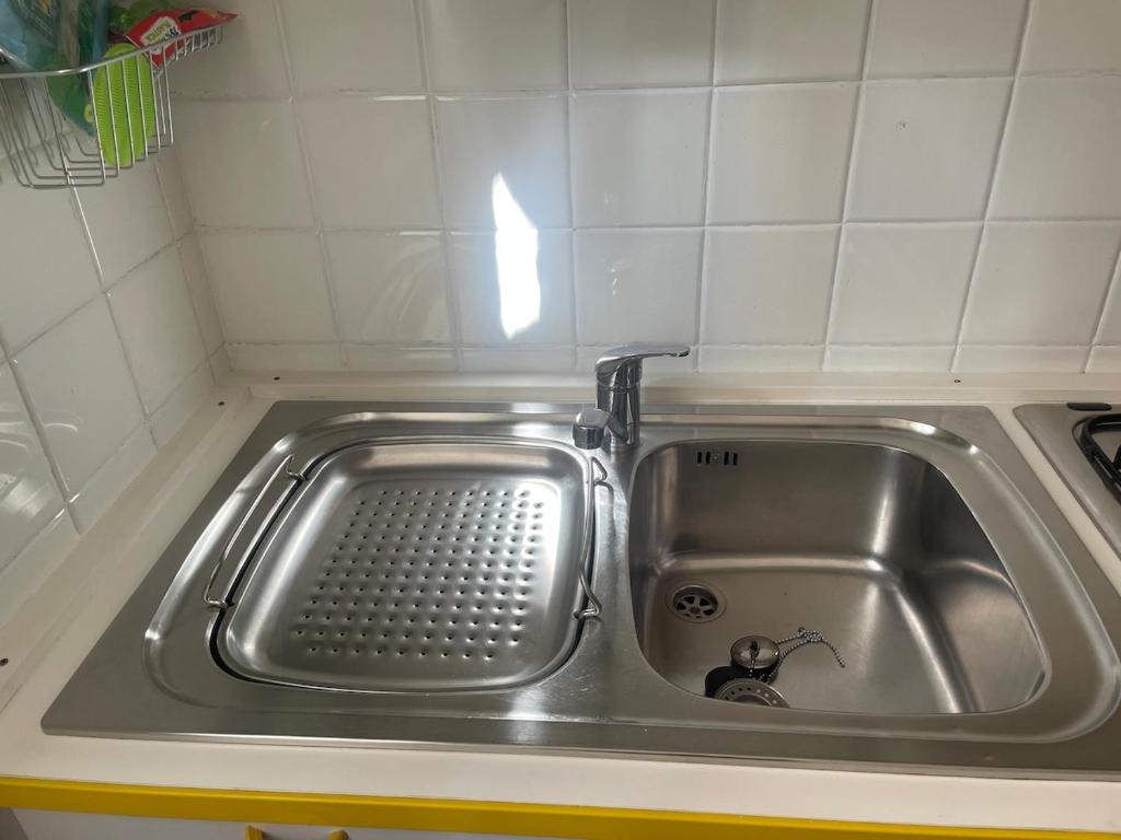a stainless steel sink with a faucet in a kitchen at Casa Terrazzino - 50 m dal mare in Bordighera