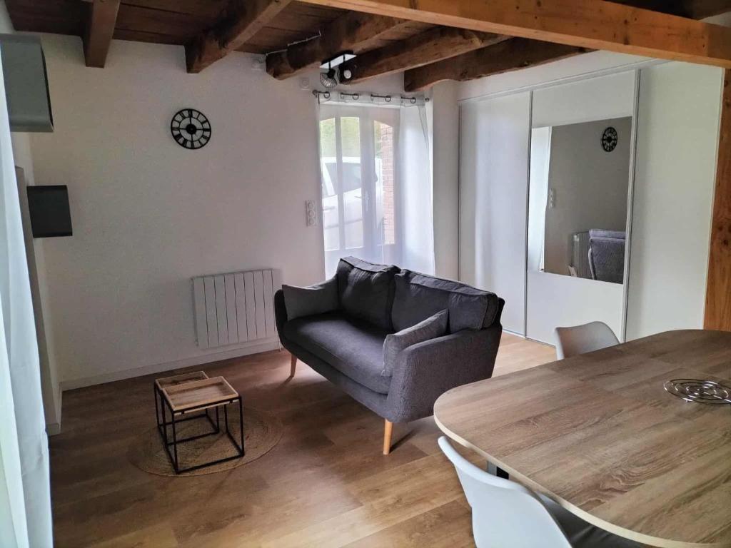 a living room with a couch and a table at Escapade nature à Langon logement rénové in Langon