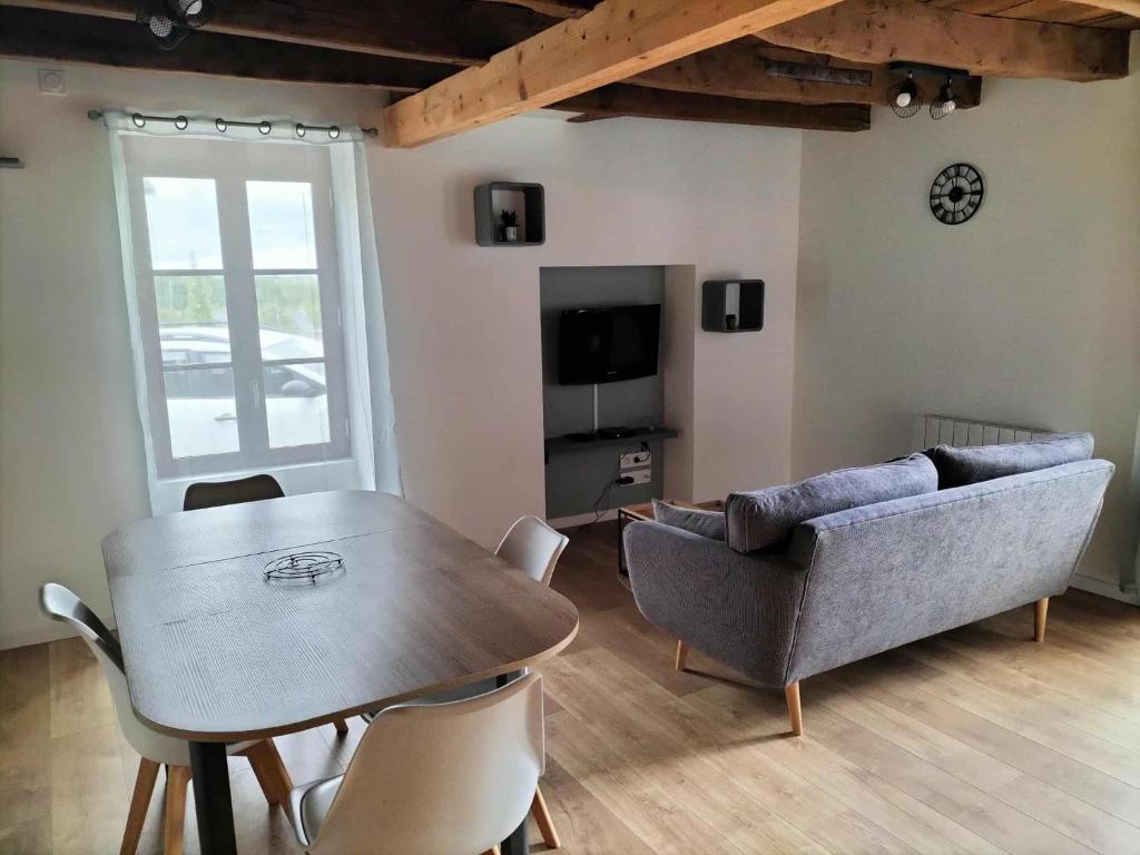 una sala de estar con una mesa y un sofá en Bel appartement rénové, en Langon