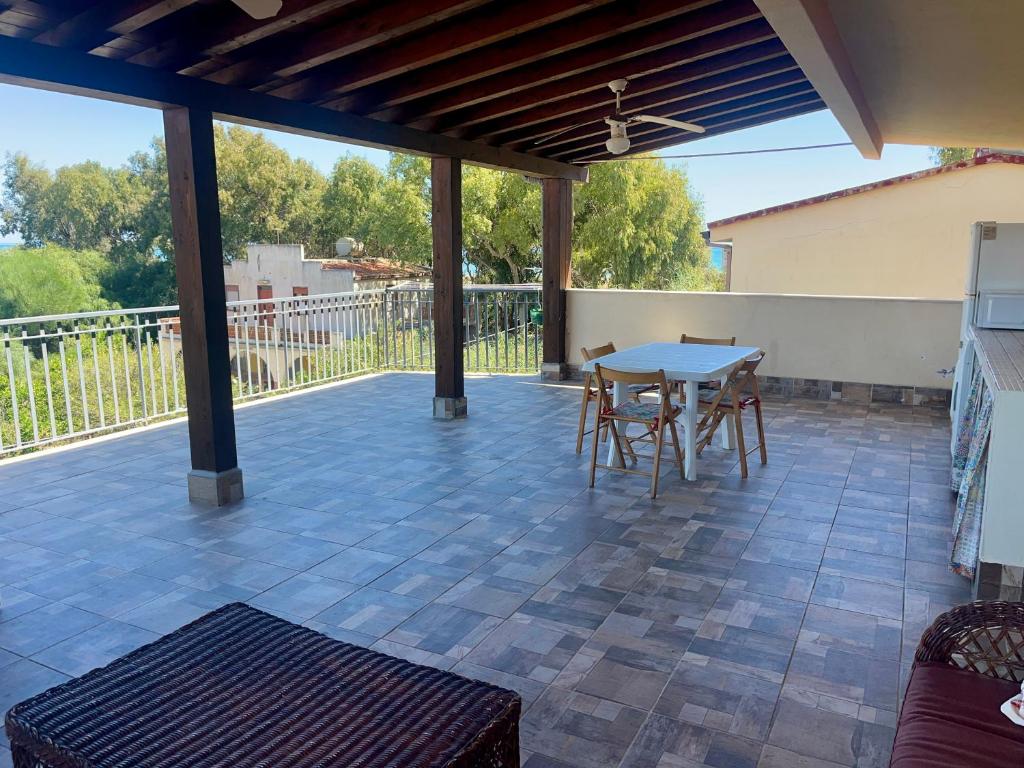 un patio avec une table et des chaises dessus dans l'établissement Etna e mare per il tuo relax, à Villaggio San Leonardo