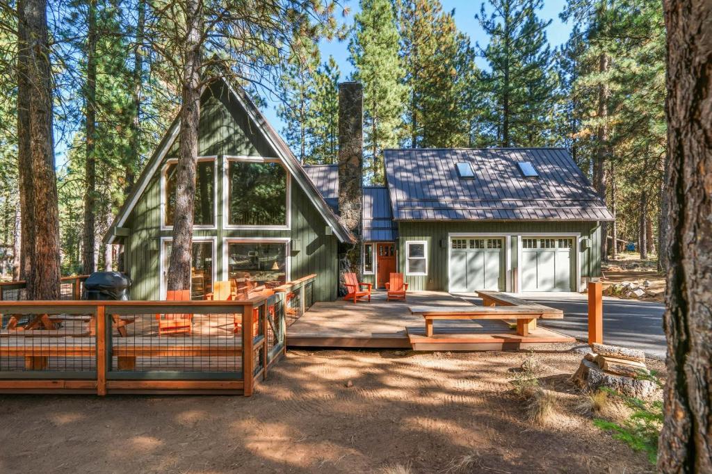 Black Butte RanchにあるSpring Home 6 - Cozy 4BR Cabin in Black Butte Ranch w Fireplaceのデッキと家のある森のキャビン