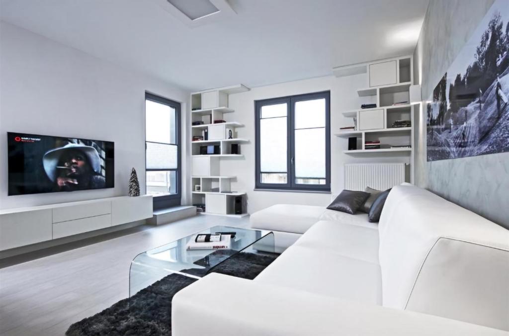 a white living room with a white couch and a tv at Modern Home 