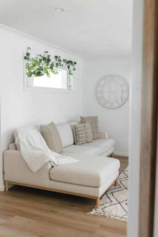 a white living room with a couch and a window at Lynwood Luxe Mudgee in Mudgee