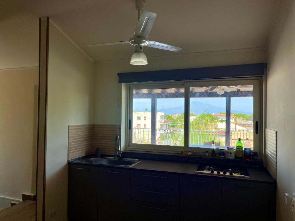 a kitchen with a sink and a window with a view at Etna e mare per il tuo relax in Villaggio San Leonardo