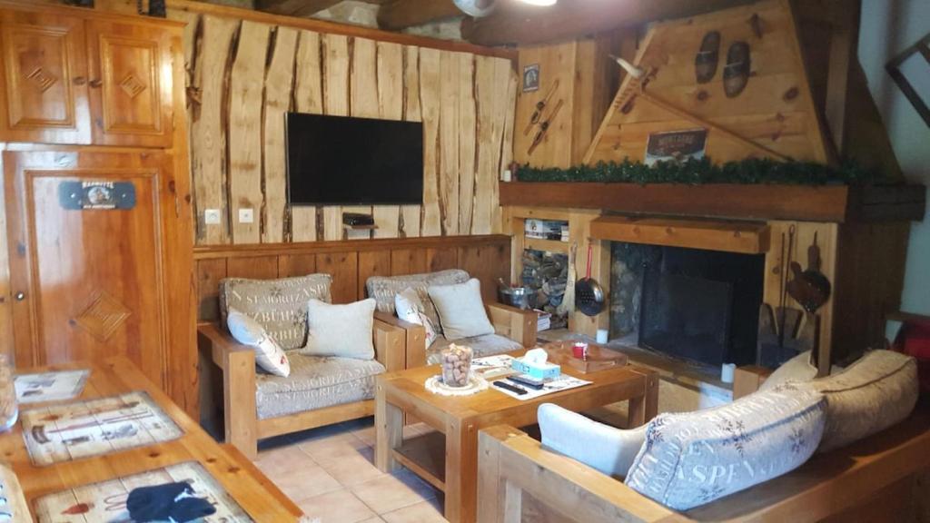 Una sala de estar con un sofá y una chimenea. en Chalet typique des Pyrénées, en Boutx