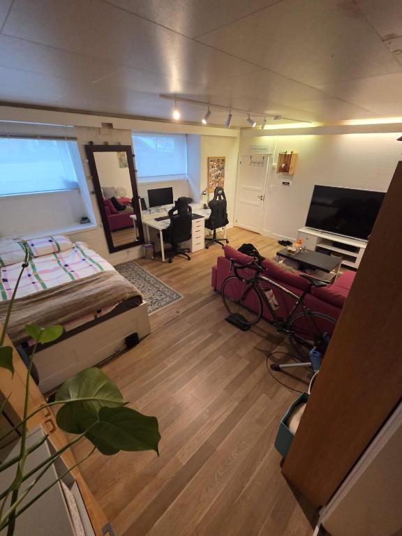 sala de estar con cama y piano en Big and cozy room in the middle of the city, en Trondheim
