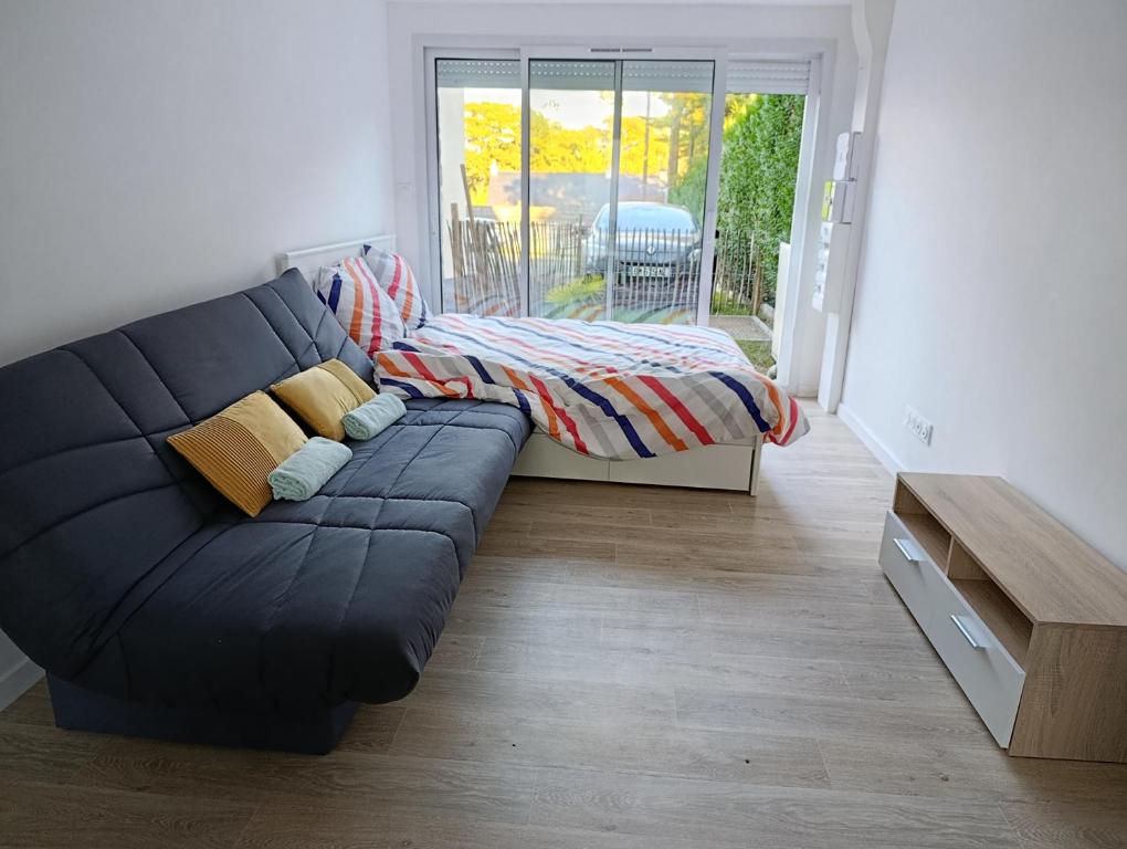 una sala de estar con un sofá y una cama en Studio Saint Marc sur Mer, en Saint-Nazaire