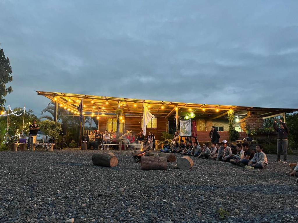 a group of people sitting on the ground in front of a building at Puyucamp in Tarqui