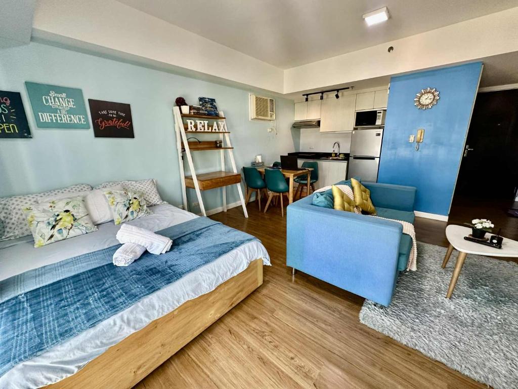 a bedroom with a blue bed and a kitchen at Bleu Suite in Abreeza Place Davao City in Sampong