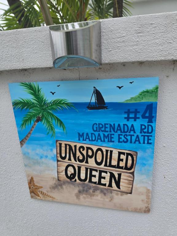 a sign on the side of a beach with a palm tree at Unspoiled Queen in Philipsburg