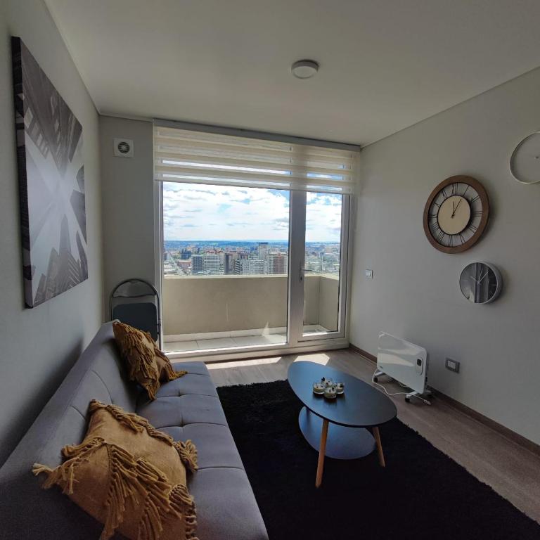 a living room with a couch and a large window at Vanguardia 924 in Temuco