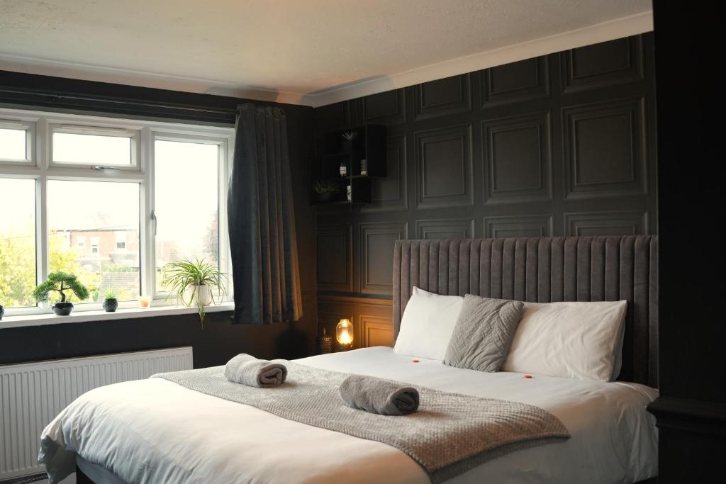 レイランドにあるDetached Homestay - Super, King & Double Rooms - Leyland, Preston, Chorley, Lancashireのベッドとタオル2枚のある寝室