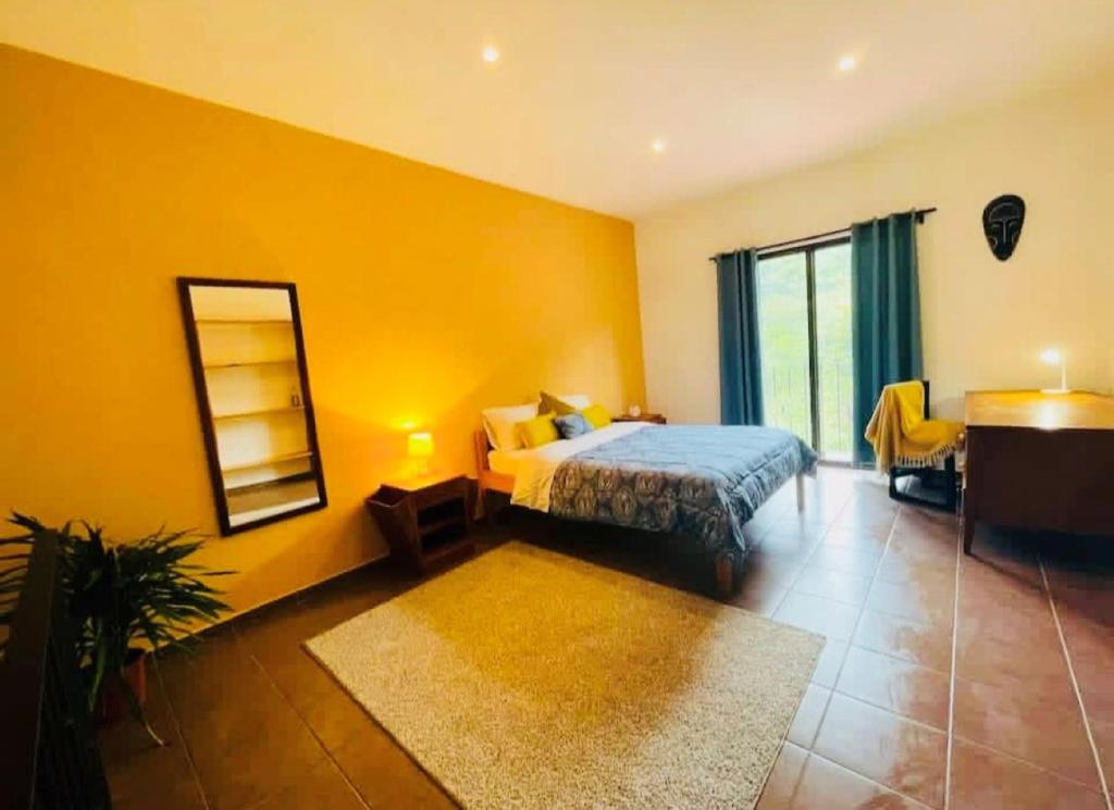 Un dormitorio con una cama, un espejo y una mesa. en Cozy and Peaceful Beach Apartment, en Playa Grande