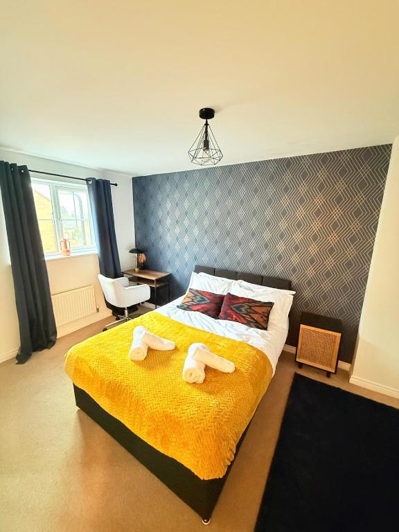 a bedroom with a bed with two towels on it at Stylish Townhouse in Rugby, sleeps up to 9! in Rugby