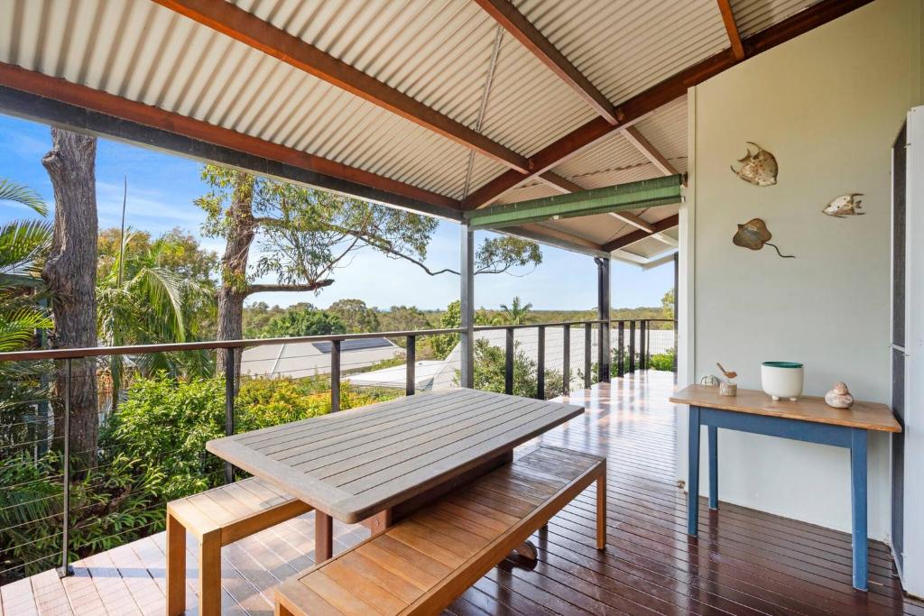 a patio with a wooden bench on a deck at Ocean View Koala Beach Retreat in Pottsville
