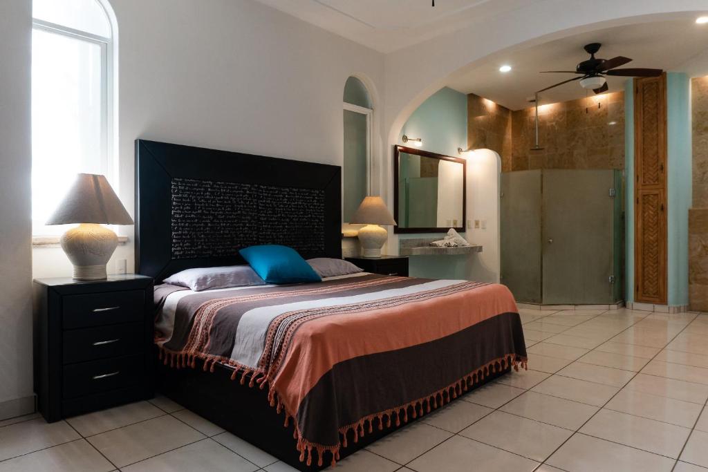 a bedroom with a large bed with a blue pillow at Say-olita in Sayulita