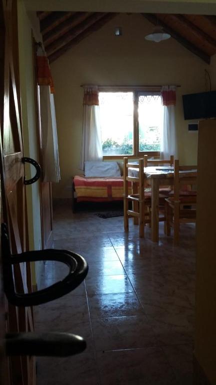 a dining room with a table and chairs and a window at La Perlita de Trevelin in Trevelín