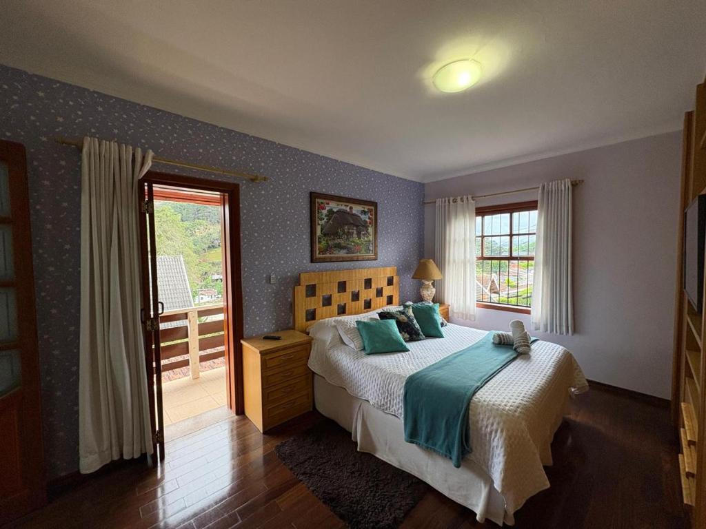 a bedroom with a large bed and a window at Pousada Atalaia Village in Campos do Jordão