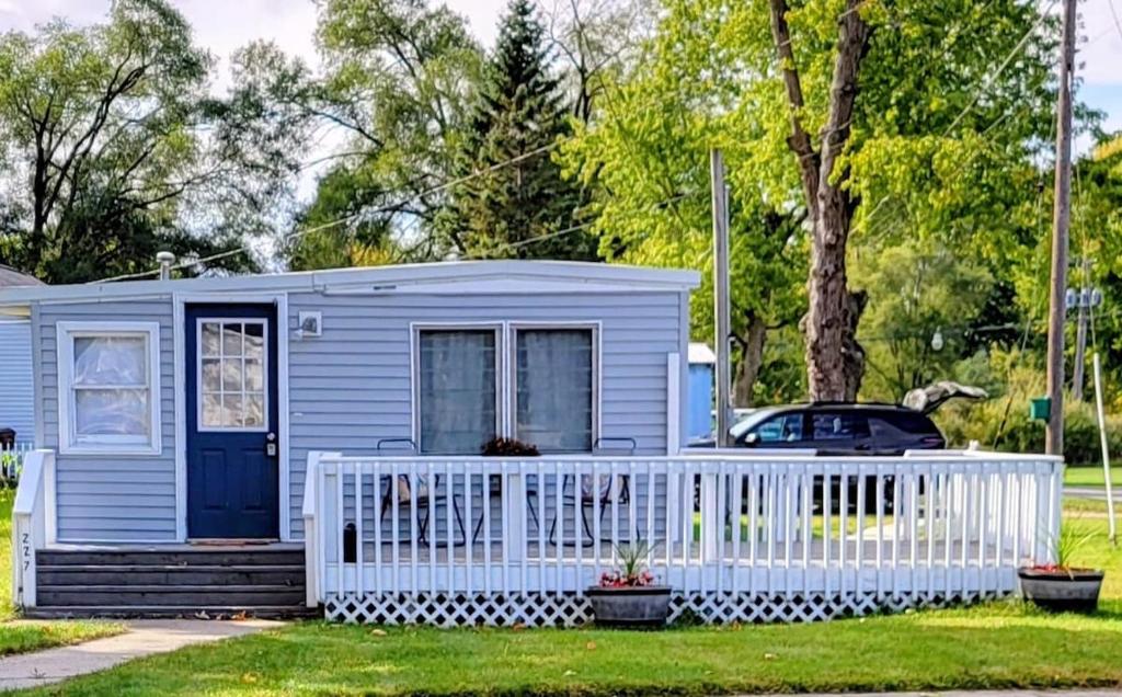 a blue tiny house with a white fence at Welcome to Bluebird Cottage in Lakeview