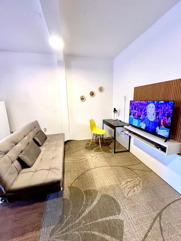a living room with a couch and a flat screen tv at Casa Buarque de Macêdo 494 in Rio Grande