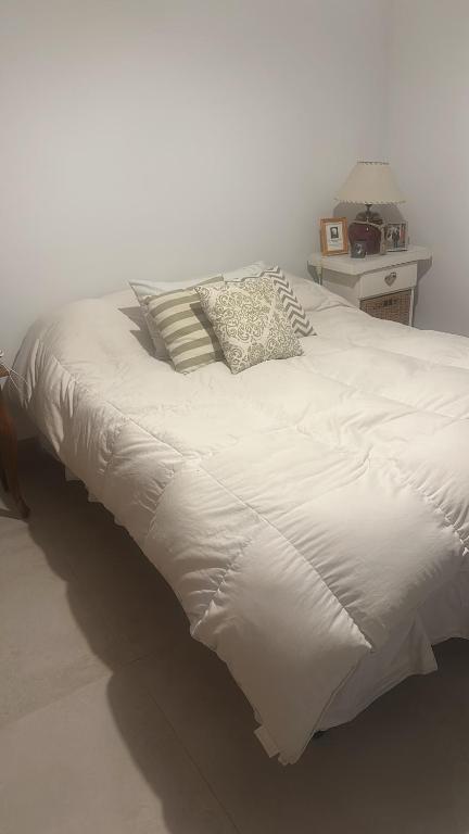 a large white bed with two pillows on it at Croeso! in Puerto Madryn