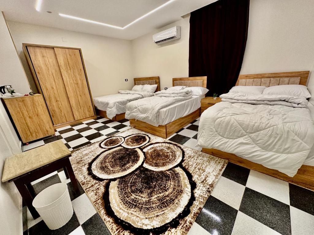 a bedroom with two beds and a checkered floor at Great Pyramids view Lodge in Cairo