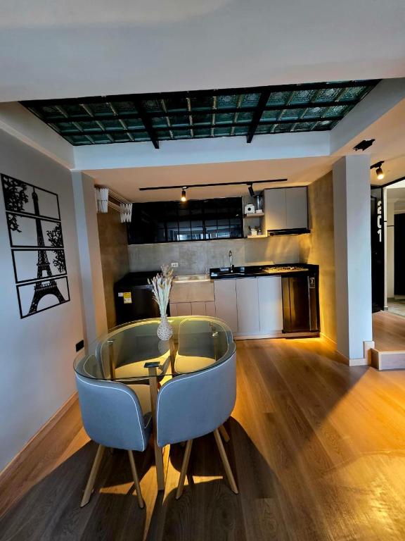 a dining room with a glass table and blue chairs at Studio Norte Tunja Moderno y acogedor in Tunja