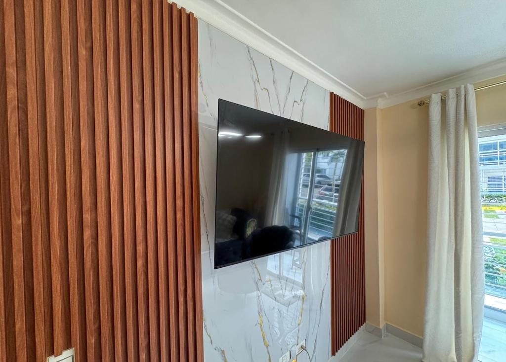 una TV a schermo piatto a parete in camera di Apartment family friendly in Santo Domingo Este a San Isidro