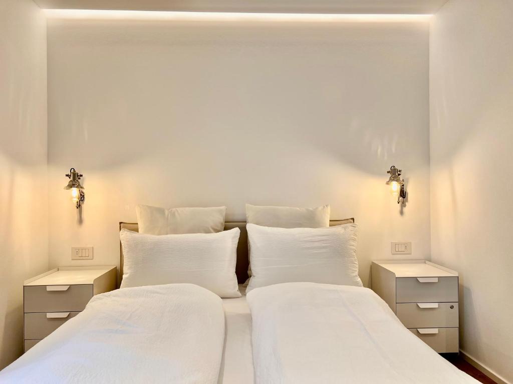 two beds in a bedroom with white walls at Villa Maria in Rablà