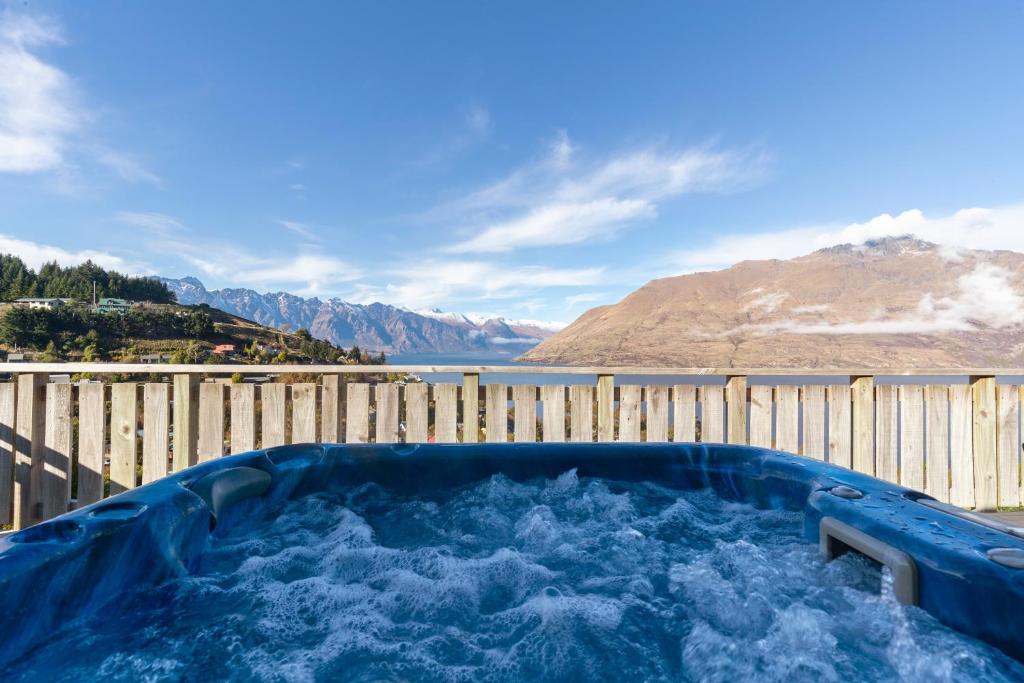 a hot tub with water in it next to a fence at Summit Serenity in Queenstown